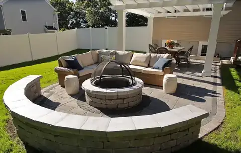 Fire pit with curved stone seating and a pergola
