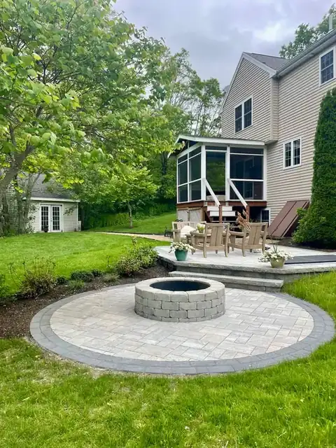 Backyard patio with fire pit beside a circular paver terrace