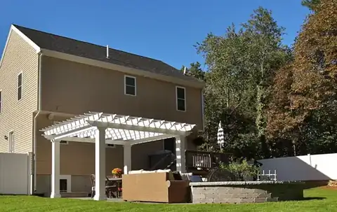 Pergola and patio behind a two-story home