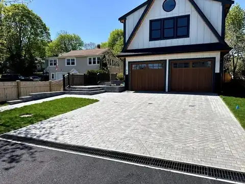 Paver driveway entrance in front of a tall house