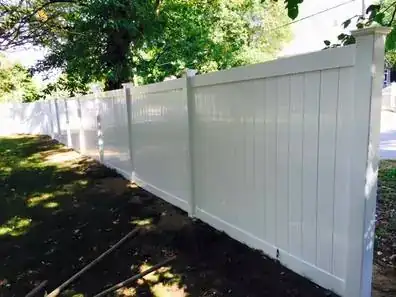 White vinyl privacy fence along a lawn