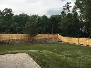 Wood privacy fence above a paver patio