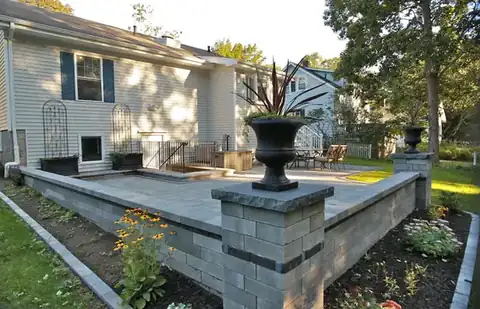 Paver patio with stone columns and a decorative urn