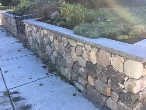 Stone retaining wall bordering a garden bed