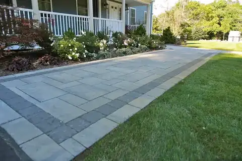 Bordered paver walkway beside a mowed lawn