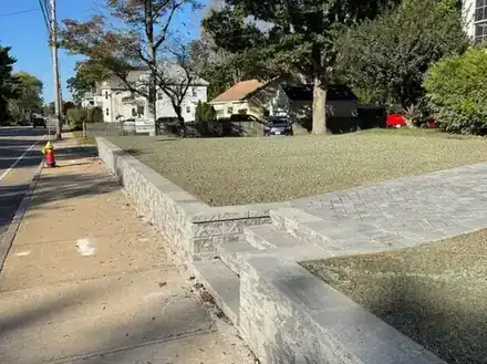 Stone wall and walkway under construction on a corner lot